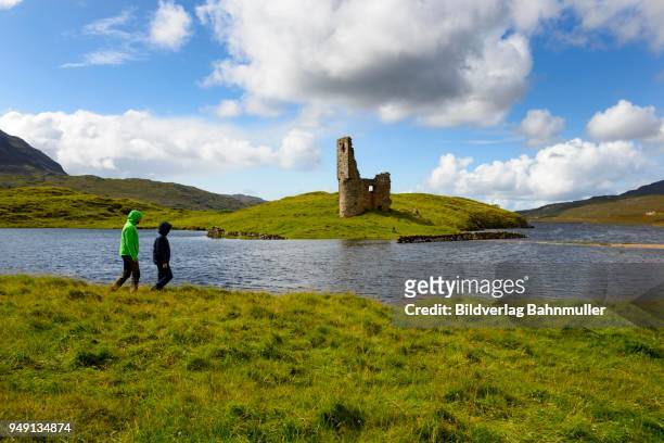 walker at the ruins of the macleods of assynt, ardvreck castle at loch assynt, sutherland, highlands, scotland, great britain - ardvreck castle stock-fotos und bilder