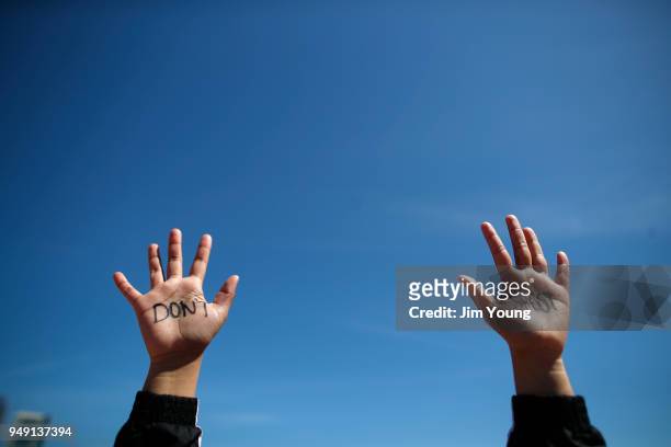 Student holds up her hands while taking part in National School Walkout Day to protest school violence on April 20, 2018 in Chicago, Illinois....