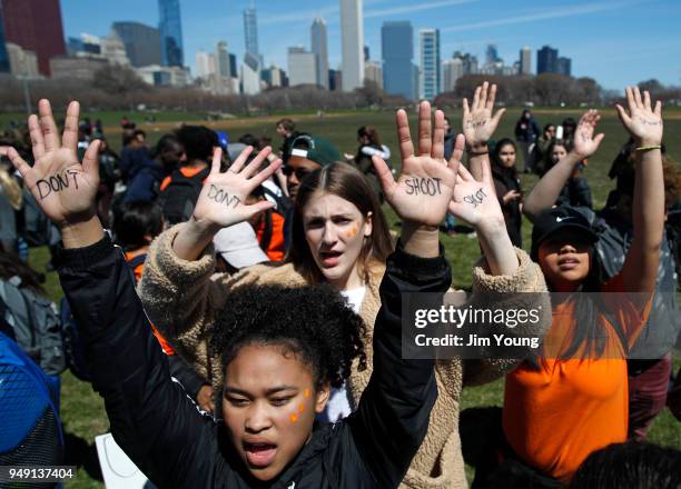 Students hold up their hands while taking part in National School Walkout Day to protest school violence on April 20, 2018 in Chicago, Illinois....