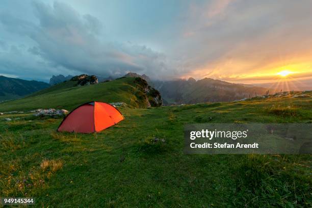 dramatic sunset with a tent in front of a cloudy sky in the mountains on the alpsigel in alpstein, bruelisau, appenzell innerrhoden, switzerland - appenzell innerrhoden stock pictures, royalty-free photos & images