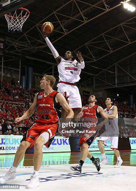 Cortez Groves of the 36'ers lays up over Shawn Redhage of the Wildcats during the round 13 NBL match between the Perth Wildcats and the Adelaide...