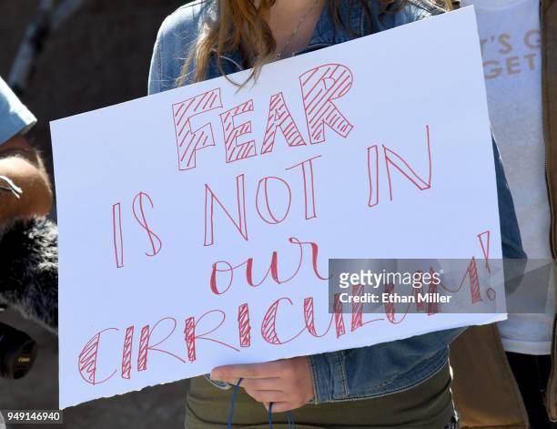 Palo Verde High School student Ainslee Archibald holds a sign outside the school as she participates in the National School Walkout on the 19th...