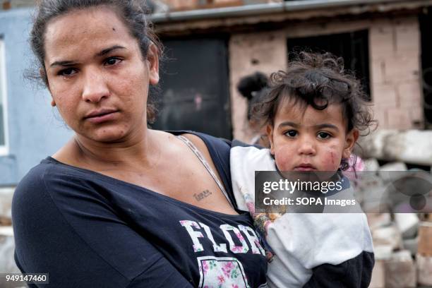 Reni, a mother of four, holds her youngest of four children, Maya after her home was razed in a Roma quarter of Sofia. At least 20 homes, deemed...