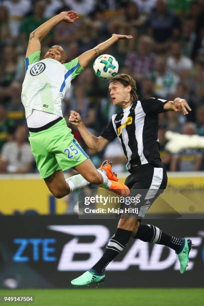 John Brooks of VfL Wolfsburg and Jannik Vestergaard of Moenchengladbach battle for the ball during the Bundesliga match between Borussia...