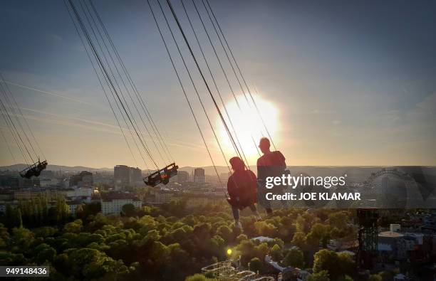 Visitors of Vienna's Prater amusement park take a ride at 117 meter high Prater Turn carousel in Vienna, Austria on April 20, 2018.