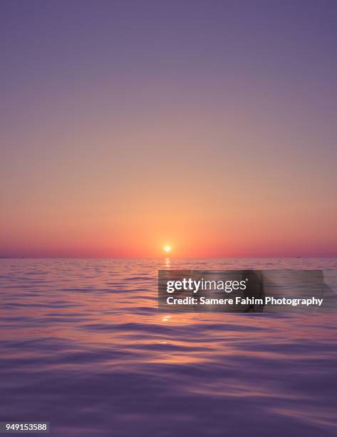 view of a calm sea against a clear sky during sunset - sunset sea stock pictures, royalty-free photos & images