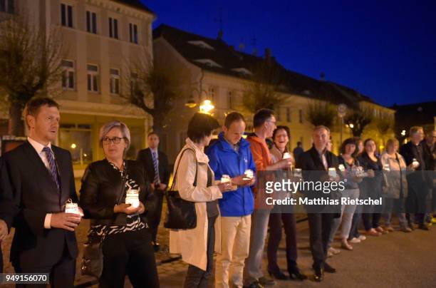 Saxony`s prime minister Michael Kretschmer, left, and other people protesting a nearby gathering of neo-Nazis and form a human chain on April 20,...