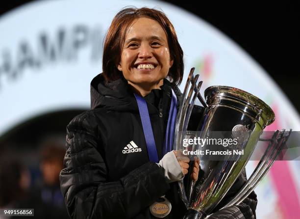 Head coach of Japan, Asako Takemoto poses with the trophy after winning the AFC Women's Asian Cup final between Japan and Australia at the Amman...