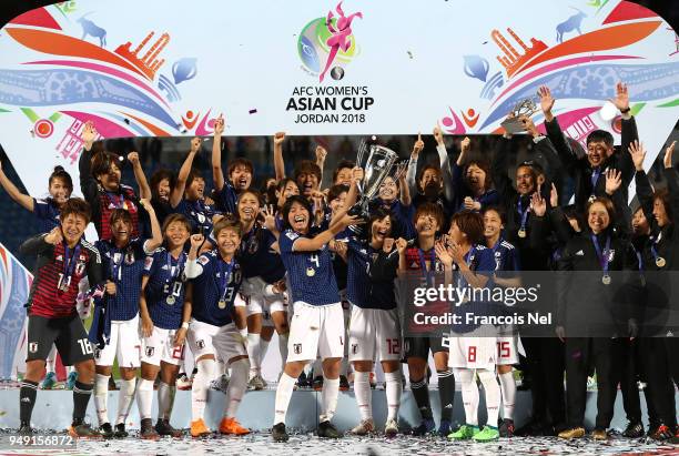 Saki Kumagai of Japan lifts the trophy after winning the AFC Women's Asian Cup final between Japan and Australia at the Amman International Stadium...