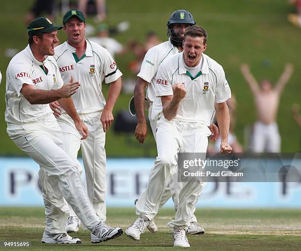Morne Morkel of South Africa celebrates with Graeme Smith and his team-mates after taking the wicket of Andrew Strauss of England for 1 run during...