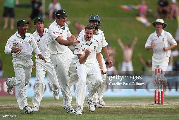 Morne Morkel of South Africa celebrates with Graeme Smith and his team-mates after taking the wicket of Andrew Strauss of England for 1 run during...