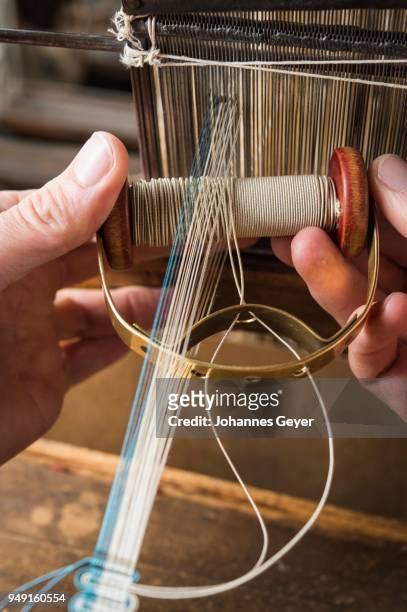 passementerie maker, hand holding beige gimp on weaving shuttle going from left to right, weaving crepine or woven border, part of crepine on handloom, munich, bavaria, germany - embellishment border stock pictures, royalty-free photos & images