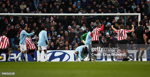 John Mensah of Sunderland scores his team's first goal as Micah Richards of Manchester City shows his dejection during the Barclays Premier League...