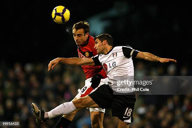 Dimitar Berbatov of Manchester United wins a header under pressure from Aaron Hughes of Fulham during the Barclays Premier League match between...