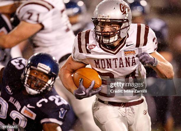 Running back Chase Reynolds of the Montana Grizzlies eludes linebacker Osayi Osunde of the Villanova Wildcats during the NCAA FCS Championship game...