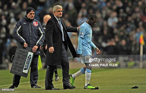 Manchester City's Welsh manager Mark Hughes consoles English midfielder Shaun Wright-Phillips as he is substituted during the English Premier League...