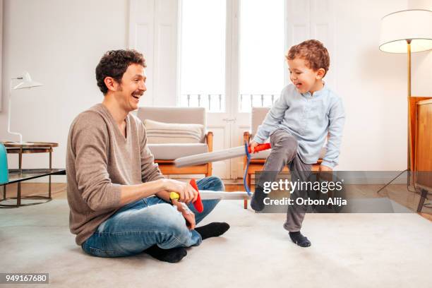 father and son fighting with wooden swords - sword stock pictures, royalty-free photos & images