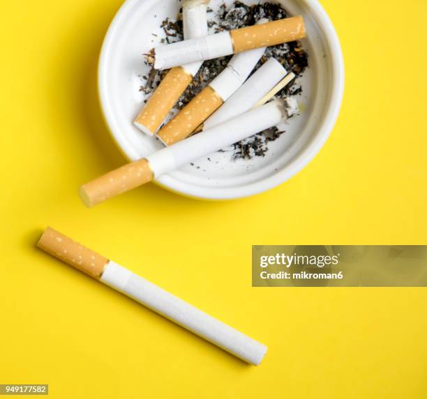 cigarettes and butts in ashtray - filtre de cigarette photos et images de collection
