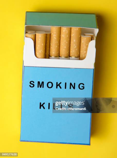 smoking kills. cigarette box on yellow background - paquete de cigarrillos fotografías e imágenes de stock