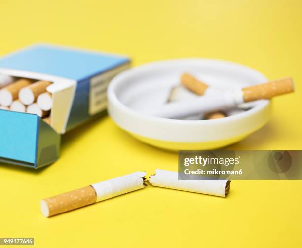 cigarettes and butts in ashtray - filtre de cigarette photos et images de collection