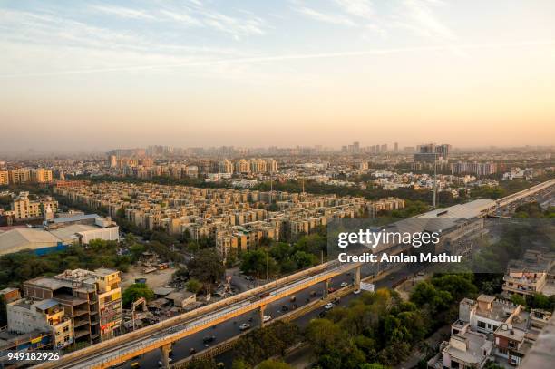 noida cityscape at dusk with the metro station, track and buildings - haryana foto e immagini stock