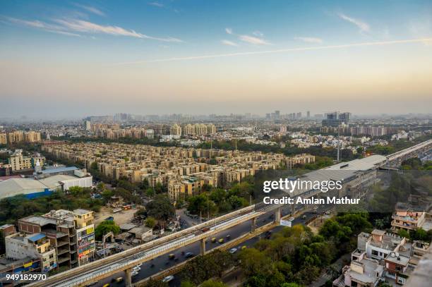 noida cityscape at dusk with the metro station, track and buildings - uttar pradesh fotografías e imágenes de stock