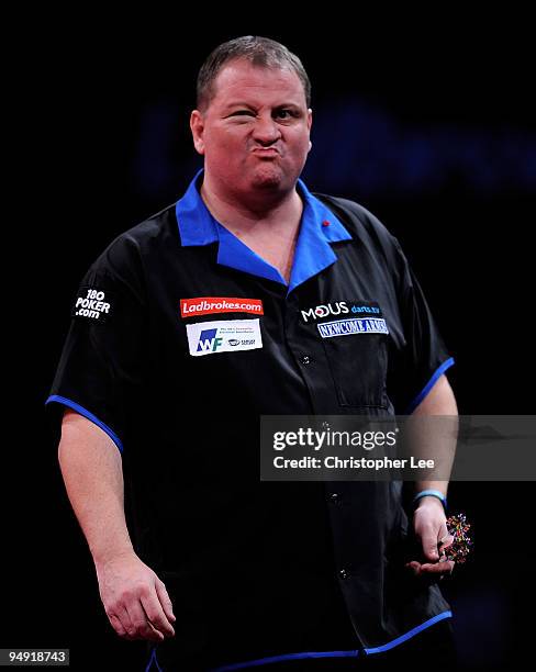 Andy Jenkins of England blows out his cheeks as he plays against Peter Manley of England during the 2010 Ladbrokes.com World Darts Championship Round...