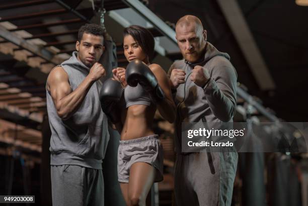 middle aged redhead handsome coach training a young athletic female kickboxer mma fighter in gym setting - 3 gym stock pictures, royalty-free photos & images