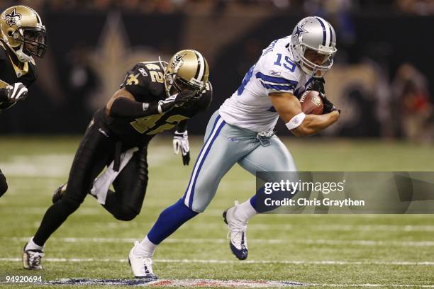 Miles Austin of the Dallas Cowboys runs after making a catch as Darren Sharper of the New Orleans Saints runs after him for the tackle in the first...