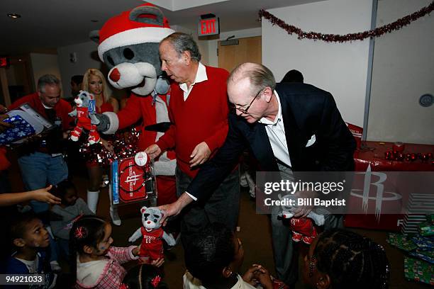 Leslie Alexander owner and Clutch mascot of the Houston Rockets and Jack Sweeney publisher of the Houston Chronicle give out gifts during the 2009...