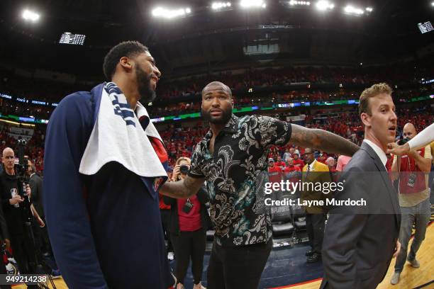 Anthony Davis of the New Orleans Pelicans speaks to DeMarcus Cousins of the New Orleans Pelicans after the game against the Portland Trail Blazers in...