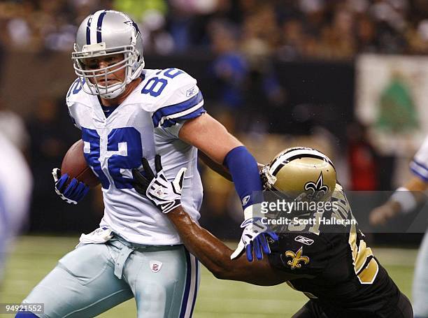 Tight end Jason Witten of the Dallas Cowboys runs with the ball as linebacker Jonathan Vilma of the New Orleans Saints trys to tackle him at the...