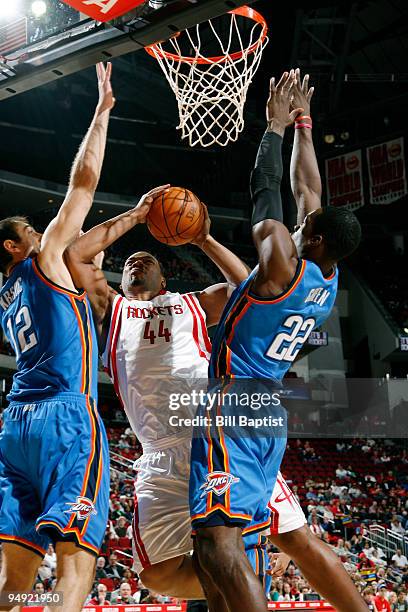 Chuck Hayes of the Houston Rockets shoots the ball over Jeff Green and Nenad Krstic of the Oklahoma City Thunder on December 19, 2009 at the Toyota...