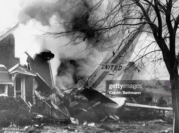 Tail section of United Airlines Boeing 737 jetliner sticks out from side of the house after crashing into a row of homes while trying land at Midway...