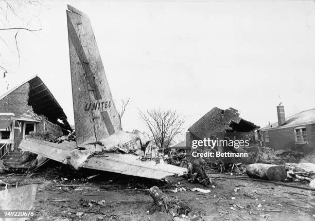 The tail section and the engine of the United Airlines jet,which crashed in a residential area near Midway airport, lies in the debris of the houses...