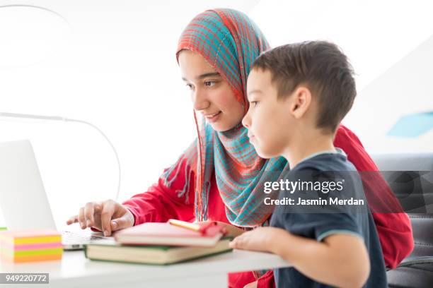 helping little boy in studying at home - two young arabic children only indoor portrait stock pictures, royalty-free photos & images