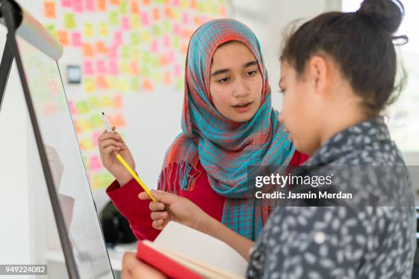 muslim girl and boy studying at home on whiteboard - two young arabic children only indoor portrait stock pictures, royalty-free photos & images