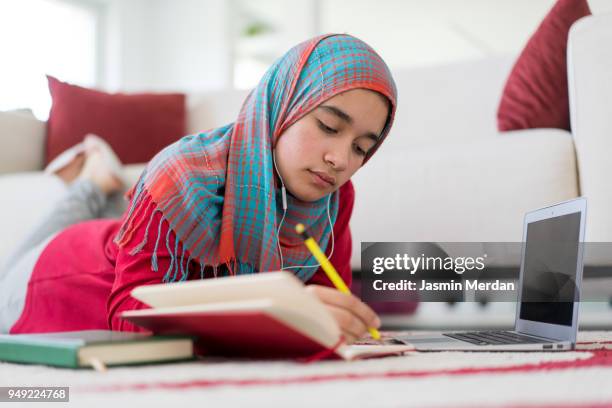 muslim girl studying at home - learn arabic stockfoto's en -beelden