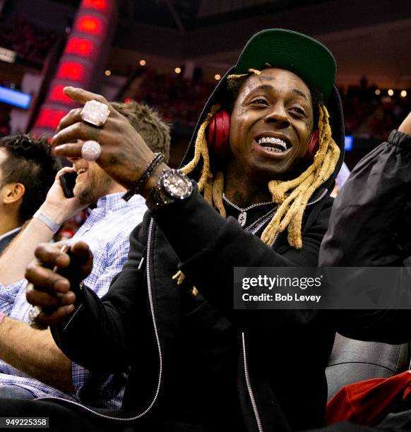 Rap artist Lil Wayne sits court-side during Game Two of the first round of the Western Conference playoffs at Toyota Center on April 18, 2018 in...