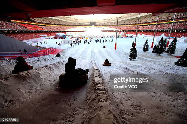 People play on artificial snow inside China's iconic national stadium, also known as the Bird's Nest, on the opening day of the 'Winter Playground' ,...