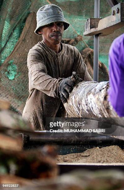 Thai Muslim man works at a rubber tree factory in Thailand's southern province of Yala on December 19, 2009. Thai consumer confidence rose to a...