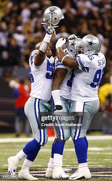 Bradie James, DeMarcus Ware and Marcus Spears of the Dallas Cowboys celebrate after Ware sacked quarterback Drew Brees of the New Orleans Saints to...