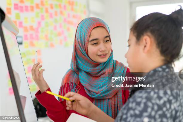 muslim girl and boy studying at home on whiteboard - beautiful arabian girls stock-fotos und bilder