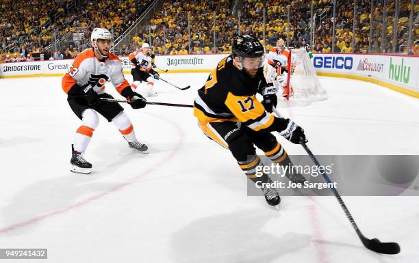 Bryan Rust of the Pittsburgh Penguins handles the puck against Shayne Gostisbehere of the Philadelphia Flyers in Game Five of the Eastern Conference...
