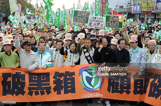 Tsai Ing-wen , chairwoman of the main opposition Democratic Progressive Party , holds a banner and chants slogans with other supporters during a...
