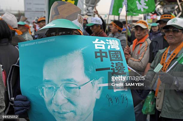 Protester displays a poster showing the former Taiwan president Chen Shui-bian calling for "China and Taiwan, one side each country", during a...