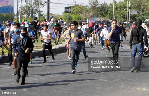 Students run away from rubber bullets and tear gas during clashes with riot police, within a protest against the government's reforms in the...