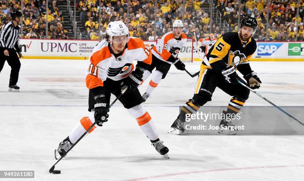 Travis Konecny of the Philadelphia Flyers takes a shot against Riley Sheahan of the Pittsburgh Penguins in Game Five of the Eastern Conference First...