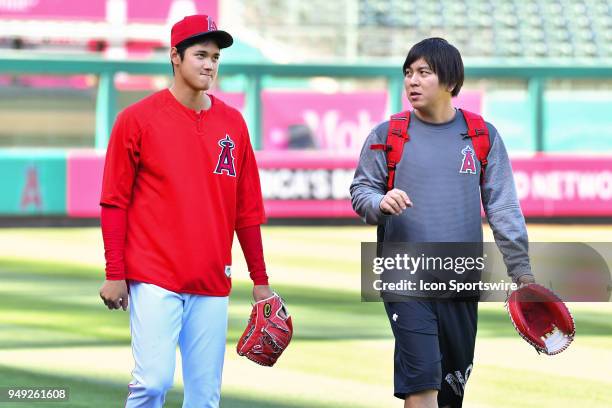 Los Angeles Angels designated hitter/pitcher Shohei Ohtani walks with his interpreter Ippie Mizuhara after throwing in the bullpen before a MLB game...