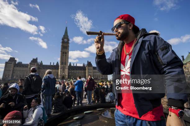 Resident smokes a large marijuana joint during the 420 Day festival on the lawns of Parliament Hill in Ottawa, Ontario, Canada, on Friday, April 20,...
